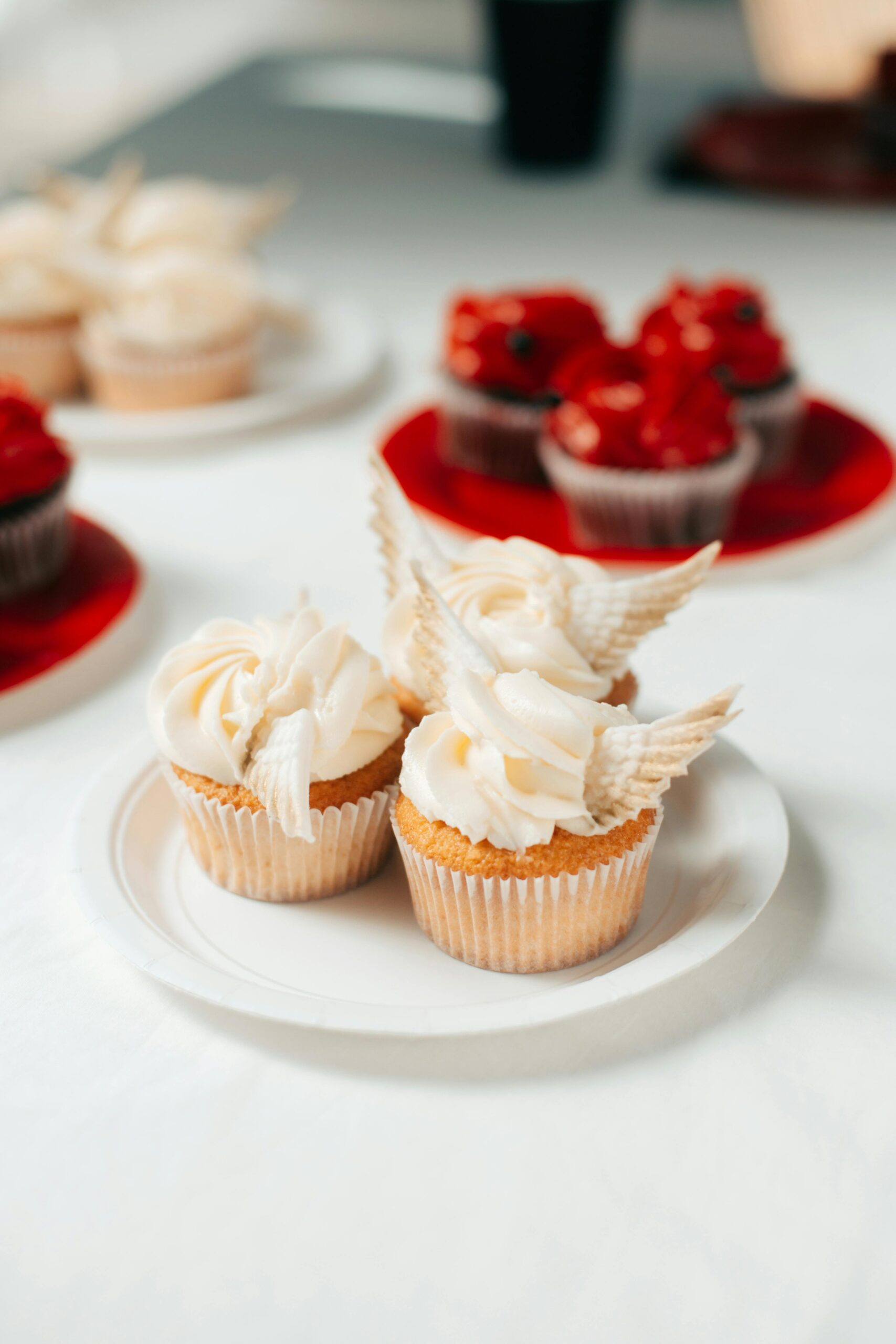 Elegant cupcakes with decorative frosting and wings, ideal for weddings and dessert events.